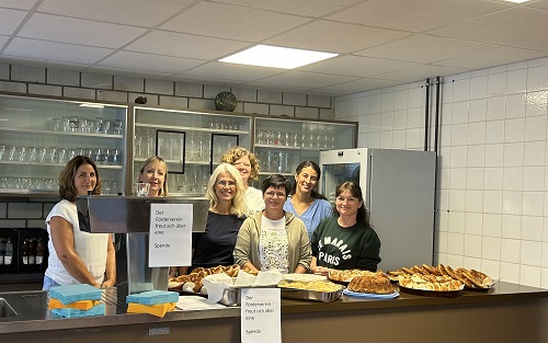 Das Team des Fördervereins steht hinter der Theke mit Kaffee und Häppchen